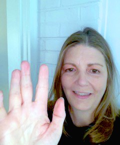 Image of Julie Hovermale with her right hand raised